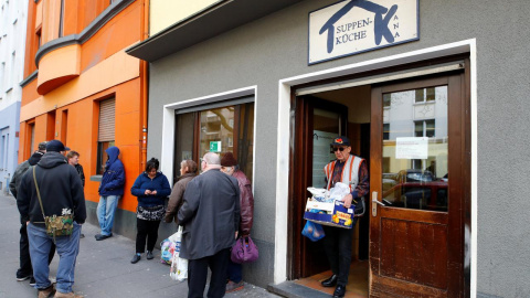 Varias personas se sitúan en la puerta de un banco de alimentos en la ciudad alemana de Dortmund./REUTERS