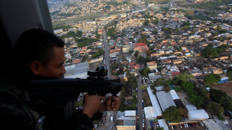 Un soldado hondureño con su fusil en un helicópero militar durante la operación denominada 'Paz y Democracia II', dentro de las medidas de seguridad en la campaña de las elecciones presidenciales. REUTERS/Jorge Cabrera