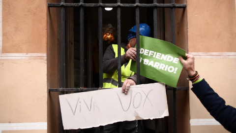 Un obrero recibe una pancarta de Vox en La Latina (Madrid), el 9 de abril de 2021.