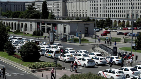 Un grupo de taxis permanecen concentrados a su paso por el ministerio de Fomento. /EFE