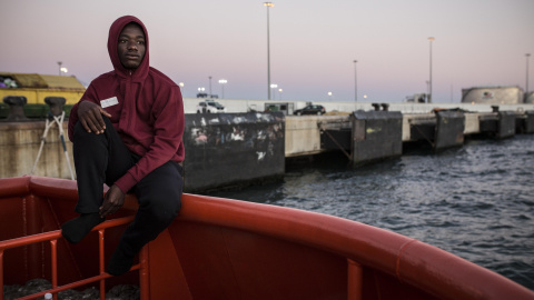 Abdoul Kalash, de 15 años y originario de Guinea Konacry, observa Algeciras desde el puerto, donde lleva durmiendo tres días seguidos tras ser rescatado en el Estrecho de Gibraltar cuando viajaba en una patera. JAIRO VARGAS