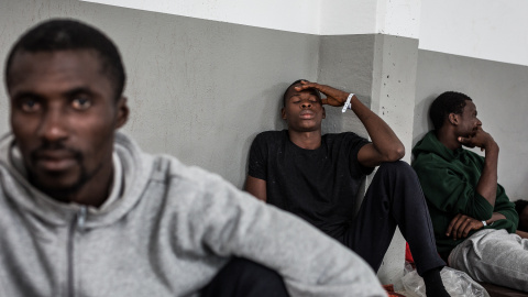 Varios migrantes descansando en una nave industrial del puerto de Barbate/Jairo Vargas