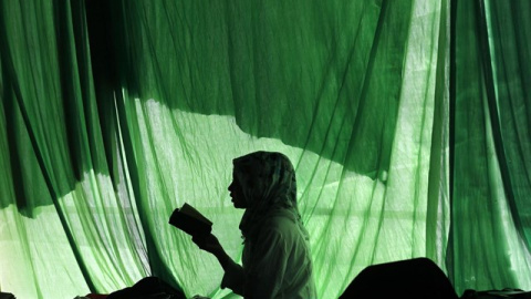 La silueta de una mujer leyendo un libro en Indonesia./REUTERS