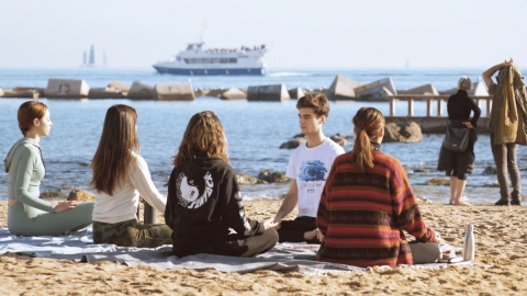 Ioga a la platja, amb els creuers al fons de la imatge