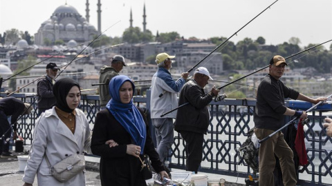 16/5/23 Varias personas en el puente de Galata, con la mezquita de Suleimán al fondo, ayer en Estambul.