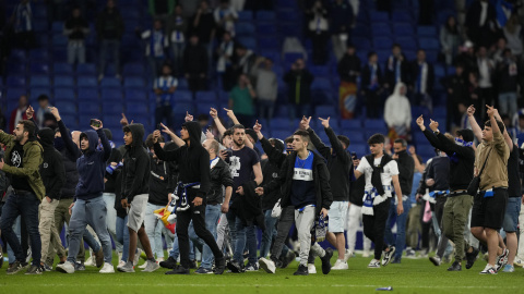 Cientos de aficionados invaden el campo al término del partido que el RCD Espanyol y el FC Barcelona