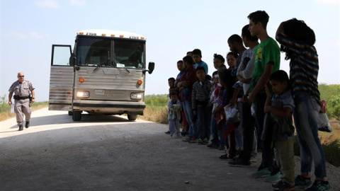 Un grupo de migrantes junto con sus hijos son parados por la Policía en EEUU. REUTERS/Archivo/Loren Elliott