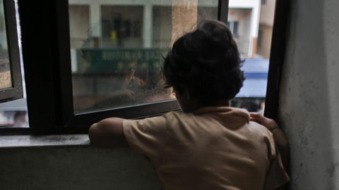 Un niño de la minoría musulmana rohingya mira por la ventana en una casa de refugiados de Kuala Lumpur, Malasia.- EFE