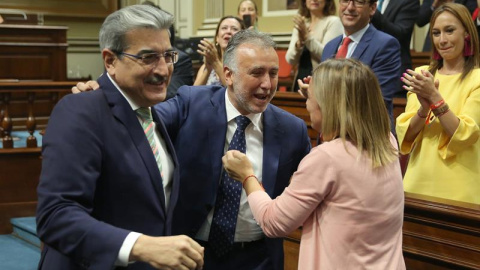 2/07/2019.- Los portavoces de los grupos de Nueva Canarias, Román Rodríguez (i), y de Si Podemos Canarias, Noemí Santana (2d), felicitan al socialista Ángel Víctor Torres (c), tras ser elegido presidente de Canarias, con el respaldo del PSO