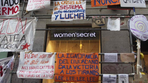 Un escaparate junto a la Puerta del Sol rodeado de carteles reivindicativos al fondo. REUTERS /Sergio Pérez