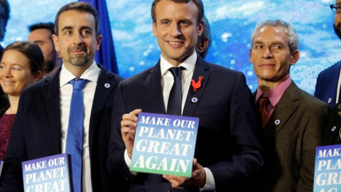 El presidente francés, Emmanuel Macron, en la cumbre One Planet Summit, con un cartel que dice "Make our planet great again".