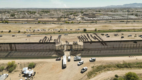 Fotografía aérea muestra hoy a cientos de migrantes mientras esperan junto al muro fronterizo en El Paso, Texas (EE.UU)