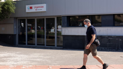 Un hombre pasea con mascarilla, frente a la entrada de urgencias del ambulatorio de Moralzarzal, a 26 de junio de 2021, en Madrid.