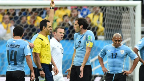 Velasco Carballo le enseña tarjeta amarilla a Diego Godín en el Uruguay-Inglaterra del Mundial de Brasil 2014. /AFP