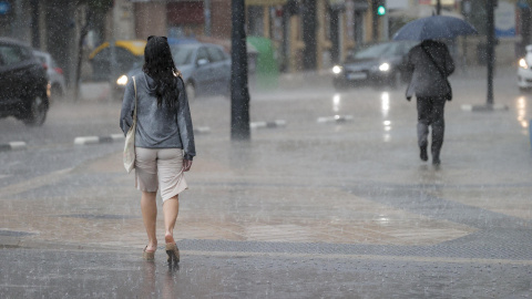 Dos personas pasean bajo la lluvia durante la tarde de este martes 23 de mayo de 2023 en València.