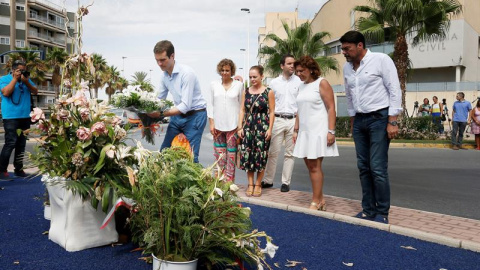 El presidente del PP, Pablo Casado (1i), deposita hoy un ramo de flores en el monolito que recuerda a las dos personas asesinadas por ETA , entre ellos una niña de 6 años, en un atentado contra la casa cuartel de Santa Pola en agosto de 200