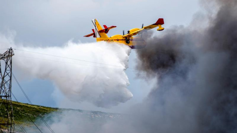 Hidroavión soltando su carga de agua para aplacar el fuego del cementerio de neumáticos en Seseña.-EFE/Ismael Herrero