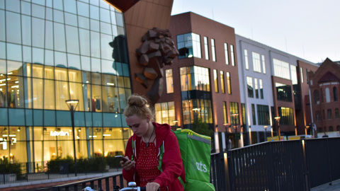 Una trabajadora de la empresa de reparto Uber Eats mira su teléfono. REUTERS/ Archivo