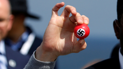 Un manifestante sostiene una pelota de golf con una esvástica dibujada en una rueda de prensa del candidato presidencial republicano Donald Trump en Turnberry Campo de golf en Turnberry , Escocia.- REUTERS / Carlo Allegri