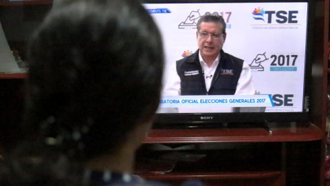 Un mujer escucha un discurso del magistrado presidente del Tribunal Supremo Electoral (TSE) David Matamoros, a través de un canal nacional de televisión en Tegucigalpa (Honduras). EFE/Gustavo Amador