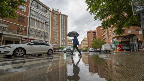 Un hombre se protege de la lluvia bajo un paraguas en Teruel, a 24 de mayo de 2023.