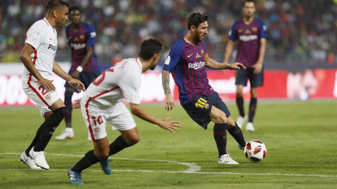 El delantero argentino del FC Barcelona Leo Messi (d) juega un balón ante Jesús Navas (c) y Gabriel Mercado, ambos del Sevilla, durante la Supercopa. EFE