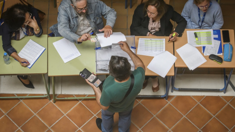 Una persona ejerce su derecho al voto en un colegio electoral de Sevilla.