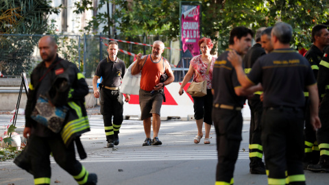 Los bomberos ayudan a los residentes de las viviendas junto al puente derruido en Génova a recoger sus pertenencias. REUTERS/Stefano Rellandini