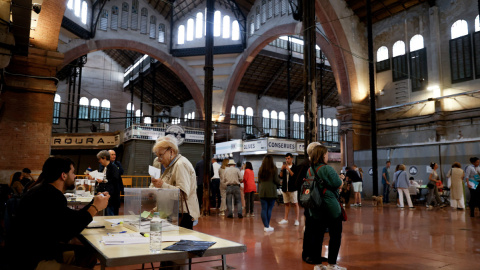 Varias personas votan en el colegio electoral situado en el Mercado de Galvany de Barcelona este domingo durante las elecciones municipales.