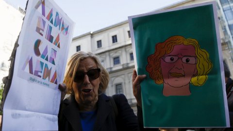 Manuela Carmena sostiene dos carteles sobre su candidatura, durante la campaña electoral. REUTERS/Sergio Perez