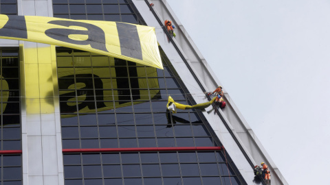 Seis activistas de Greenpeace han escalado la fachada sur de una de las dos Torres Kio para protestar por las negociaciones que llevan a cabo la Unión Europea y Estados Unidos para dar luz verde al Tratado Transatlántico de Libre Comercio e