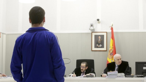 Jon Vicente Egurcegui (de espaldas) declarando en la Audiencia Nacional por publicar de forma continuada en redes sociales comentarios en los que ensalzaba a la banda terrorista ETA. EFE/Zipi