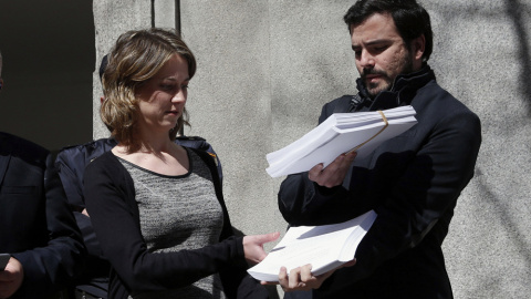 El portavoz de IU en el Congreso, Alberto Garzón, y la eurodiputada Marina Albiol muestran la querella que han presentado en el Tribunal Supremo contra el presidente del Gobierno en funciones, Mariano Rajoy, por un presunto delito de "críme