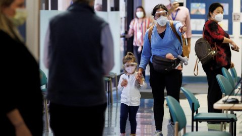 Una mujer y su hija, con mascarillas para evitar contagios de covid-19.