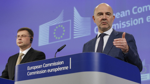 El comisario europeo de Asuntos Económicos y Monetarios, Pierre Moscovici, y el vicepresidente para el Euro y el Diálogo Social, Valdis Dombrovskis, durante una rueda de prensa celebrada en Bruselas. EFE/OLIVIER HOSLET