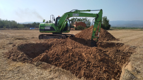 Una máquina excavadora hace una zanja en Corera (La Rioja)