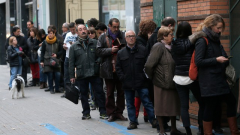 Varias personas hacen cola para votar en un colegio de Barcelona minutos antes de que abra sus puertas. /REUTERS