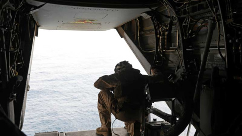 Un marine estadounidense mira desde un avión que vigila las aguas del Golfo de Omán. (AHMED JADALLAH | REUTERS)