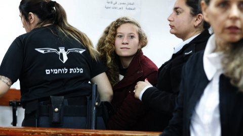 La adolescente palestina  Ahed Tamimi, es escoltada por agentes de la policía israelí hacia un juzgado en la localidad de Betunia (Palestina). EFE/ Abir Sultan