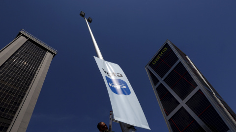 Un operario retira un banderola con la propaganda electoral del PP, en de farola en la madrileña Plaza de Castilla. REUTERS/Susana Vera