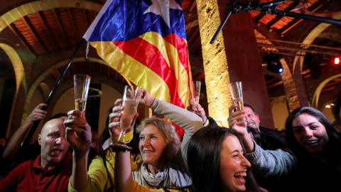 Varias personas celebran los resultados de las elecciones del 21-D en la sede de la Asamblea Nacional Catalana (ANC) en Barcelona. REUTERS / Albert Gea