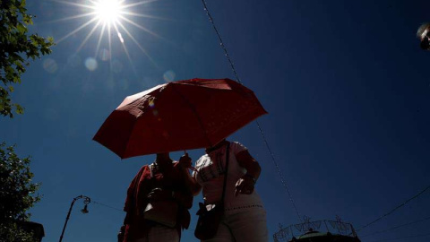 Dos mujeres se protegen con un paraguas de sol en Pamplona. (JESÚS DIGES | EFE)