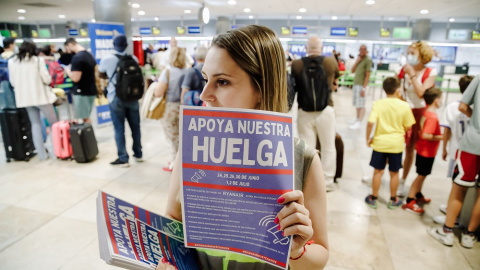 01/07/2022. Una trabajadora de Ryanair con carteles durante una concentración en la Terminal 1 del Aeropuerto Adolfo Suárez Madrid Barajas, a 1 de julio de 2022