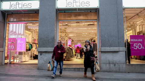 Dos personas salen con varias bolsas de una tienda , a 7 de enero de 2022, en Madrid (España).