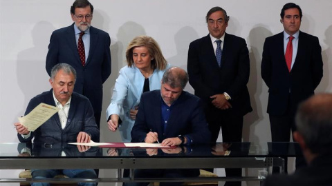 Los secretarios generales de CCOO y UGT, Unai Sordo (d) y Pepe Álvarez (i), en presencia del presidente del Gobierno, Mariano Rajoy; la ministra de Empleo y Seguridad Social, Fátima Báñez, y el presidente de la CEOE, Juan Rosell (d), durant