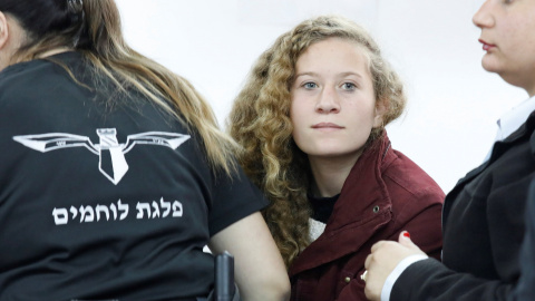 La adolescente palestina  Ahed Tamimi, es escoltada por agentes de la policía israelí hacia un juzgado en la localidad de Betunia (Palestina). EFE/ Abir Sultan