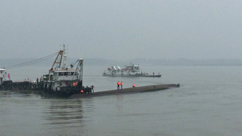 Una grúa intenta voltear al barco hundido en el río Yangtsé. /REUTERS