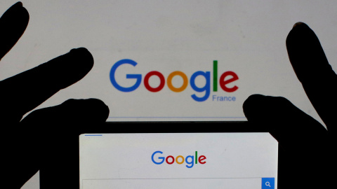 Una mujer sostiene la cámara de su smartphone frente a la portada de Google en Francia. REUTERS/Eric Gaillard