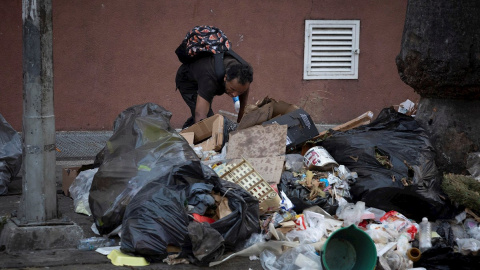 Una persona busca en restos de basura el 8 de febrero de 2021, en Caracas (Venezuela).