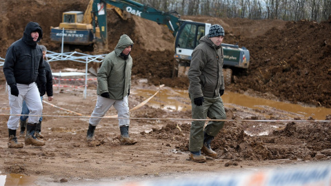 Expertos forenses, miembros de la Comisión Internacional de Personas Desaparecidas (ICMP) y trabajadores bosnios buscan mientras llueve restos humanos en Tomašica, en una imagen de archivo tomada en 2013